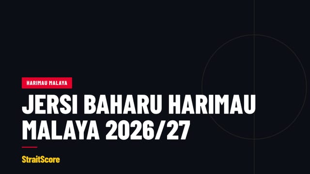 Dua jersi bola sepak digantung bersebelahan di atas dinding gelap.